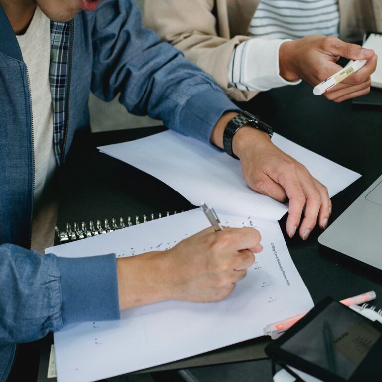 Dos personas estudian sobre la misma mesa.