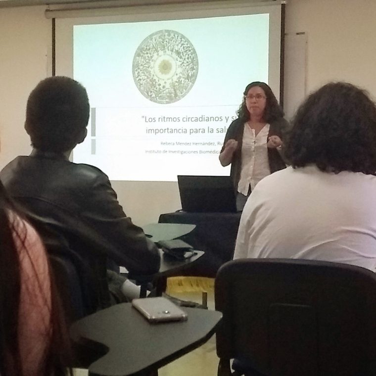 Rebeca da una clase enfrente de un grupo de 3 estudiantes.